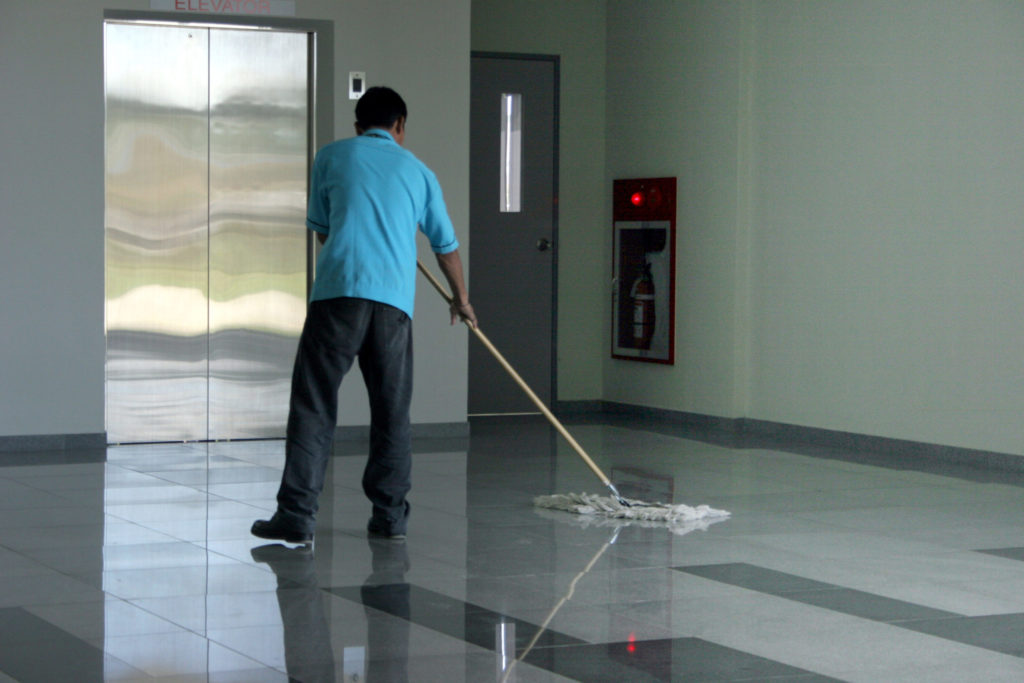 Janitorial service provider mopping polished and sealed concrete floor